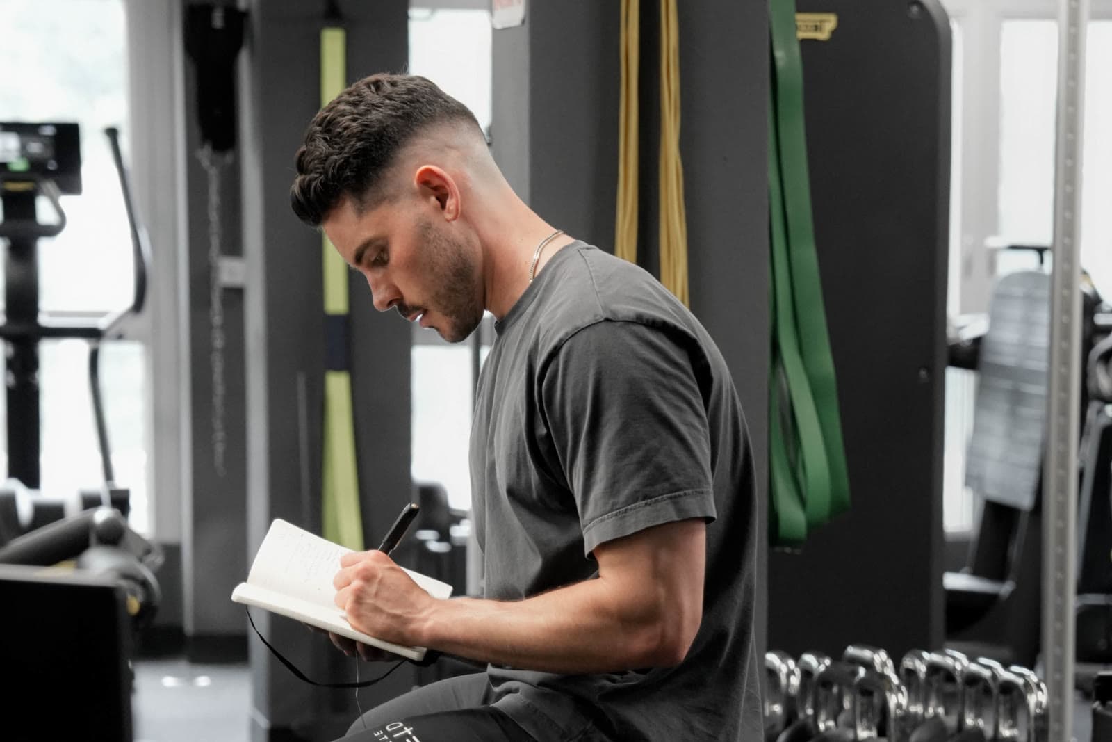 Daniel Day writing in a notebook in the gym